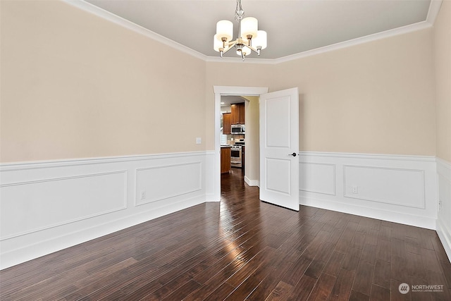 empty room featuring dark hardwood / wood-style flooring, ornamental molding, and a notable chandelier