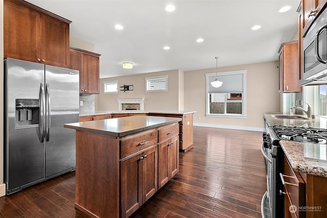 kitchen featuring pendant lighting, a center island, stainless steel appliances, and dark hardwood / wood-style flooring