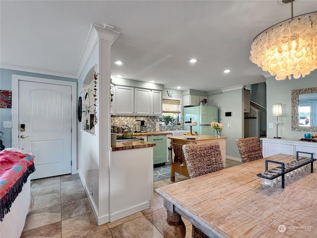 tiled dining space with ornamental molding and sink