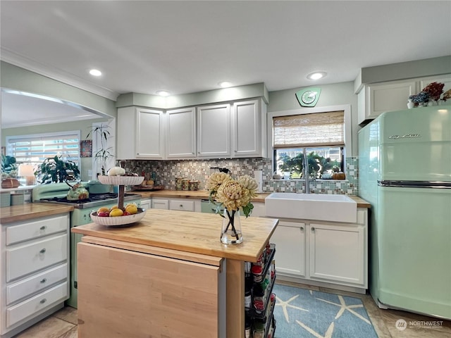 kitchen with sink, refrigerator, white cabinetry, wood counters, and decorative backsplash