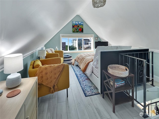 bedroom featuring light wood-type flooring and vaulted ceiling