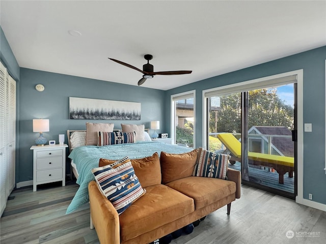 bedroom with hardwood / wood-style floors, access to outside, and ceiling fan