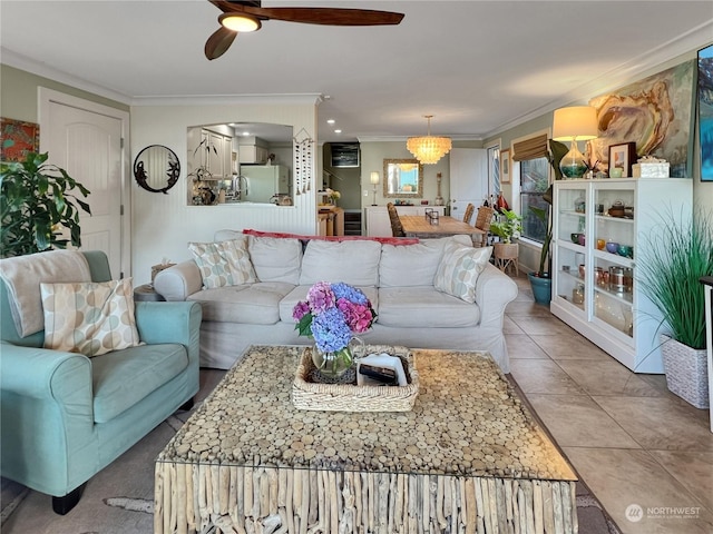 living room featuring ceiling fan with notable chandelier, light tile patterned flooring, and crown molding