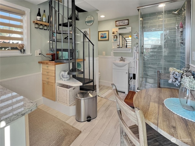 interior space featuring vanity, toilet, and a shower with shower door