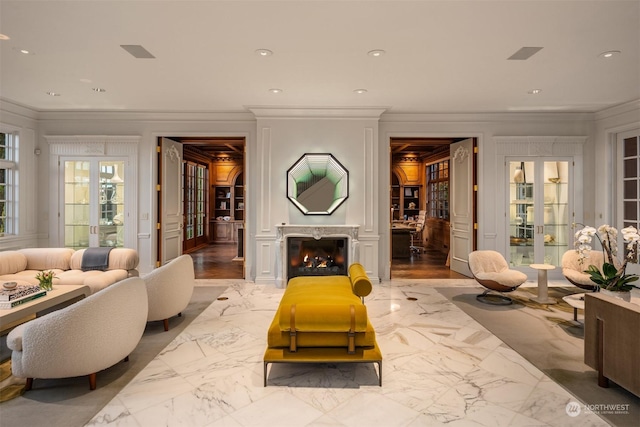 living room with french doors, a high end fireplace, and ornamental molding