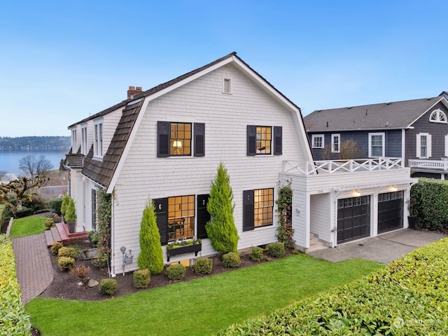 view of front of home featuring a garage, a front yard, and a water view