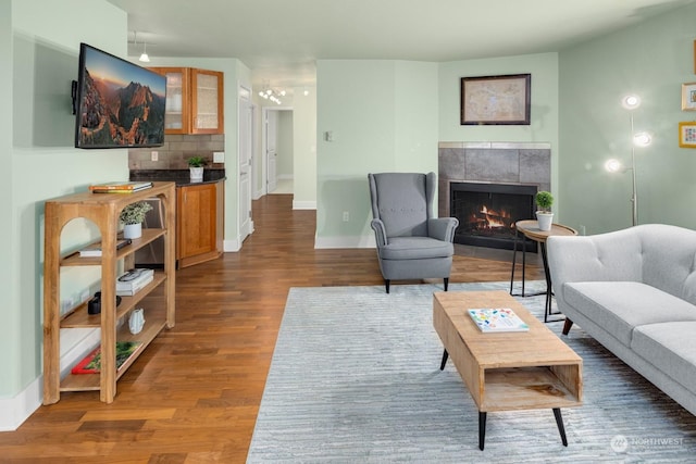 living room with dark hardwood / wood-style flooring and a tile fireplace