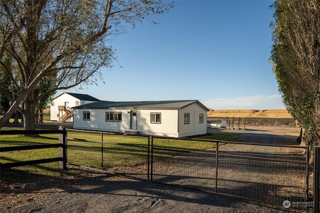 view of front of house with a rural view and a front yard