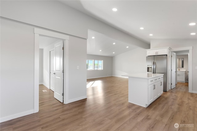 kitchen featuring white cabinetry, stainless steel fridge with ice dispenser, light hardwood / wood-style flooring, lofted ceiling, and a kitchen island