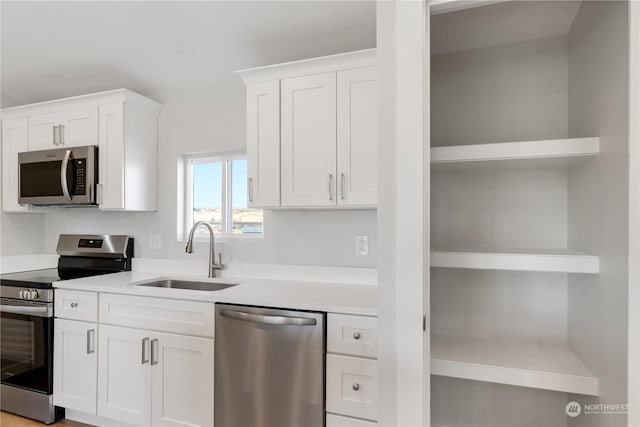 kitchen with white cabinetry, sink, and stainless steel appliances