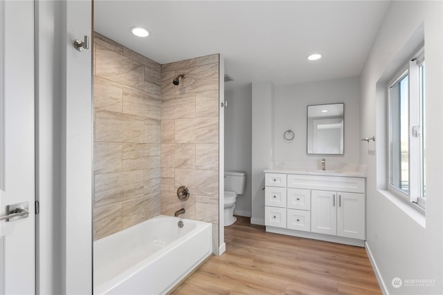 full bathroom featuring wood-type flooring, vanity, toilet, and tiled shower / bath