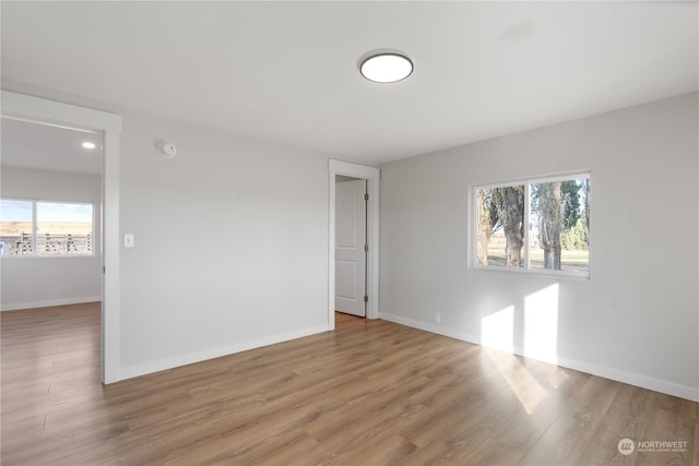 empty room featuring a healthy amount of sunlight and wood-type flooring