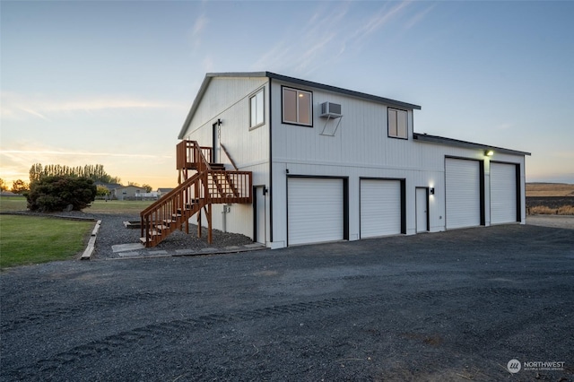 exterior space featuring a garage and a wall unit AC