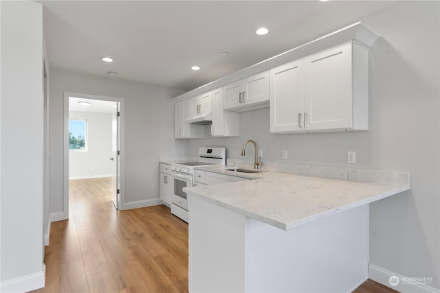 kitchen featuring kitchen peninsula, white cabinetry, sink, and white stove