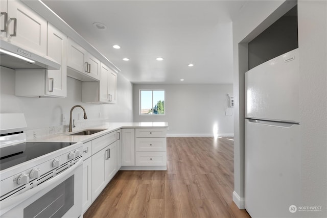 kitchen featuring white cabinets, white fridge, extractor fan, and electric range oven