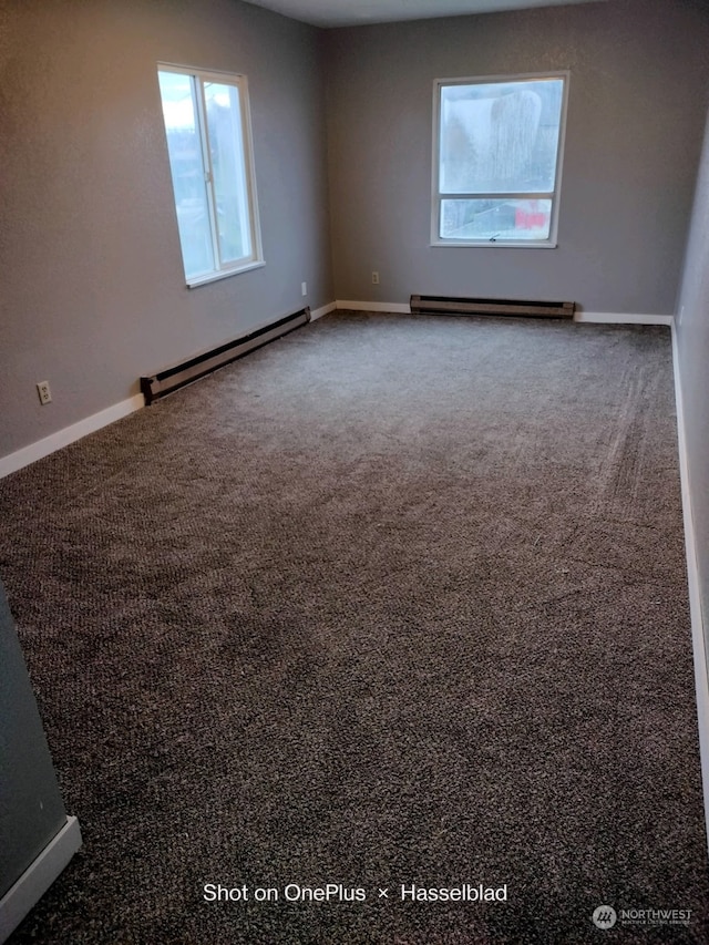 empty room with carpet floors and a baseboard heating unit