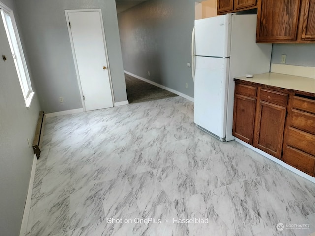 kitchen featuring white refrigerator and a baseboard heating unit