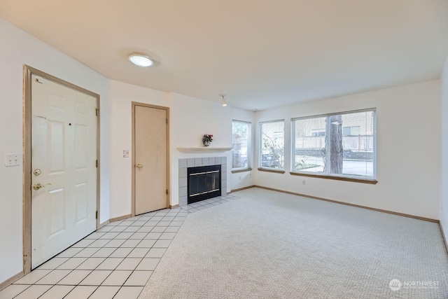 unfurnished living room featuring a tiled fireplace and light colored carpet