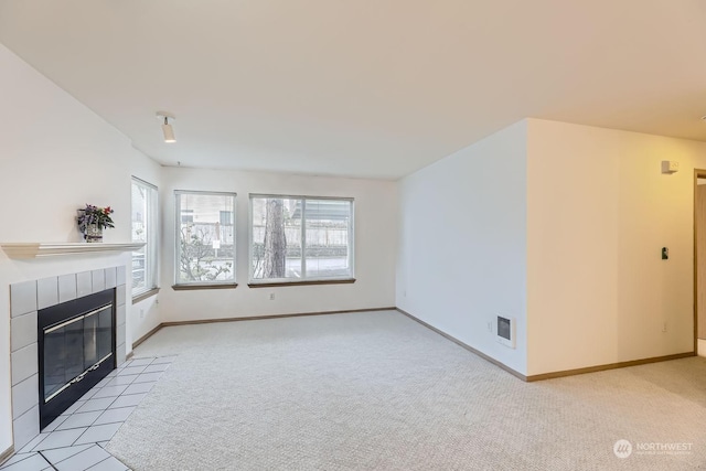 unfurnished living room featuring light colored carpet and a tile fireplace