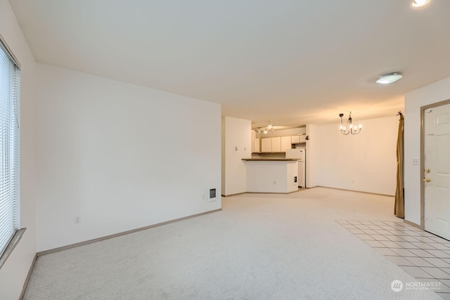 unfurnished living room featuring light carpet and a chandelier