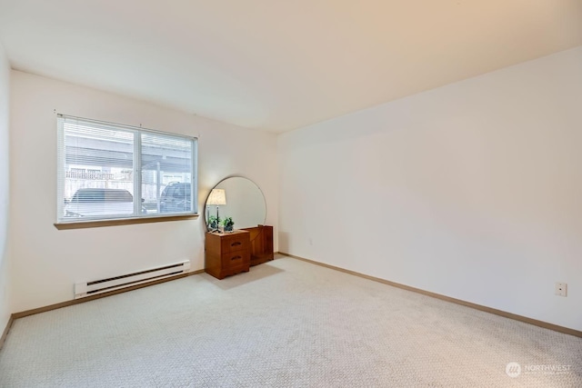 carpeted spare room featuring a baseboard heating unit