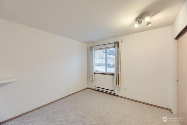 carpeted empty room with baseboard heating