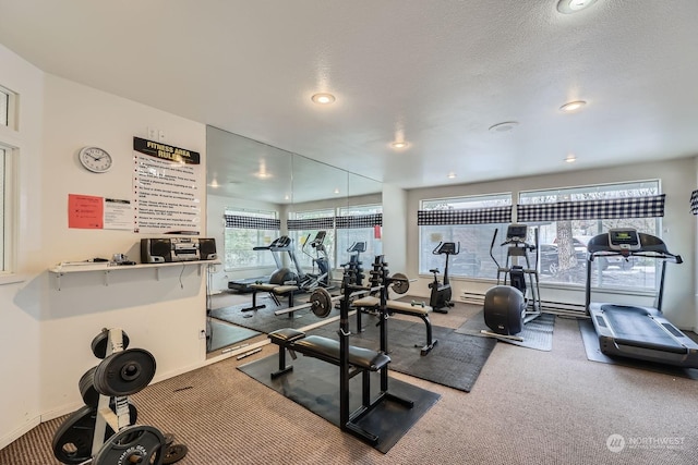 exercise room featuring carpet flooring and a textured ceiling