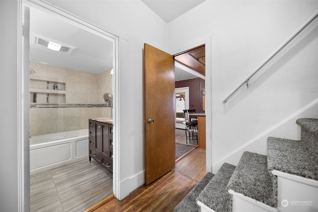 bathroom with tiled shower / bath, vanity, and hardwood / wood-style flooring