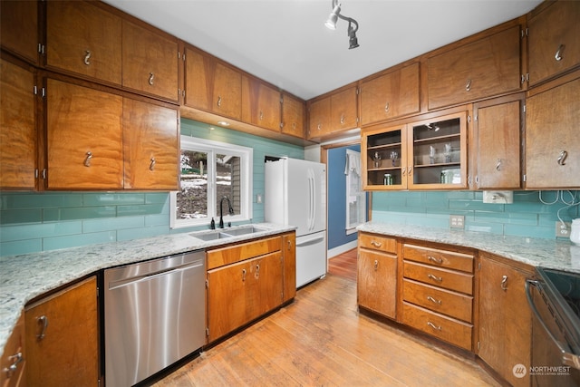 kitchen featuring sink, stainless steel dishwasher, white fridge, light hardwood / wood-style floors, and range