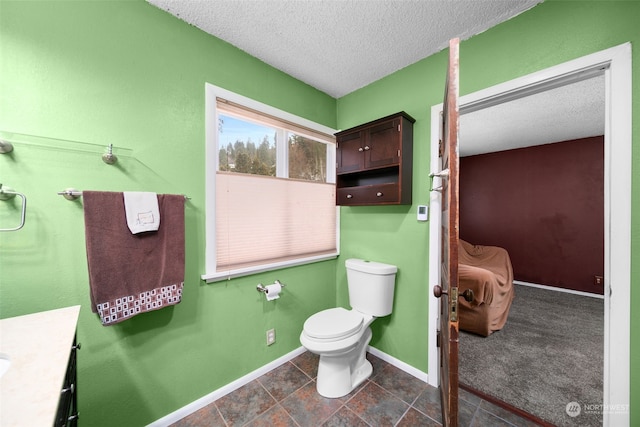 bathroom with vanity, a textured ceiling, and toilet