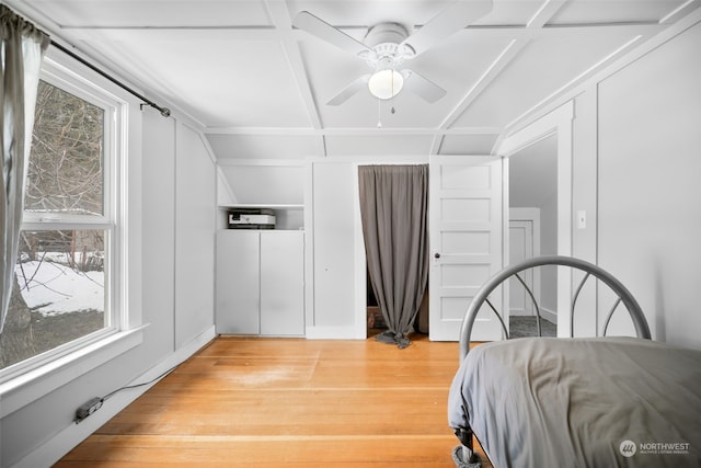 bedroom featuring ceiling fan, light wood-type flooring, and coffered ceiling