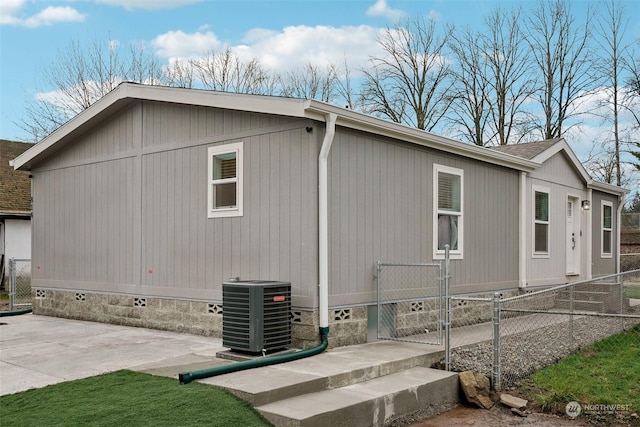 view of side of home with central AC