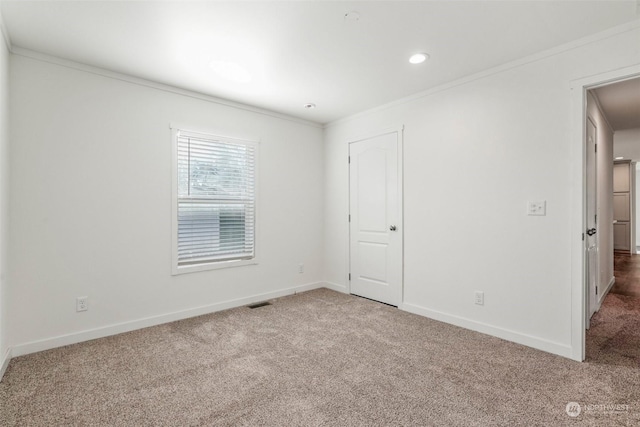 carpeted spare room featuring ornamental molding