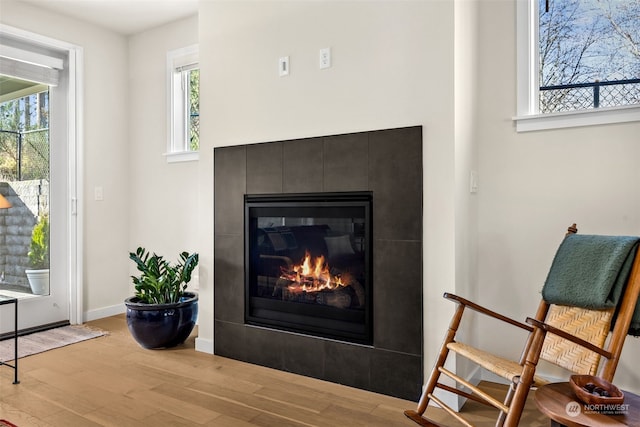 interior details featuring hardwood / wood-style floors and a tile fireplace