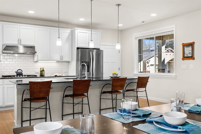 kitchen with decorative light fixtures, a breakfast bar area, and appliances with stainless steel finishes