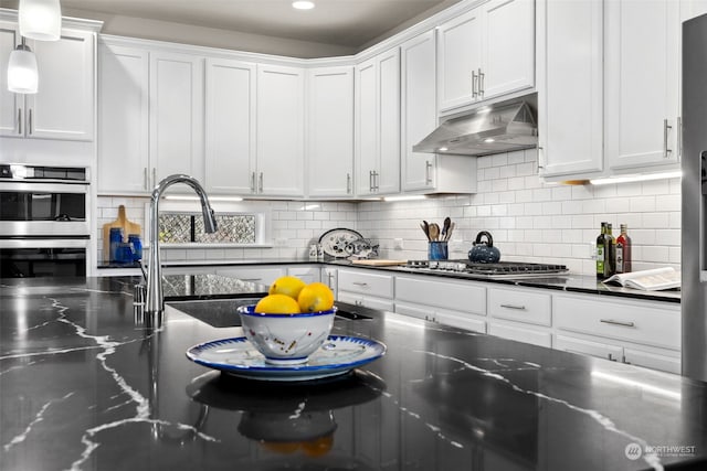 kitchen featuring sink, white cabinetry, tasteful backsplash, appliances with stainless steel finishes, and pendant lighting