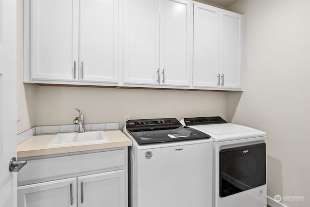 laundry room featuring sink, cabinets, and washer and dryer