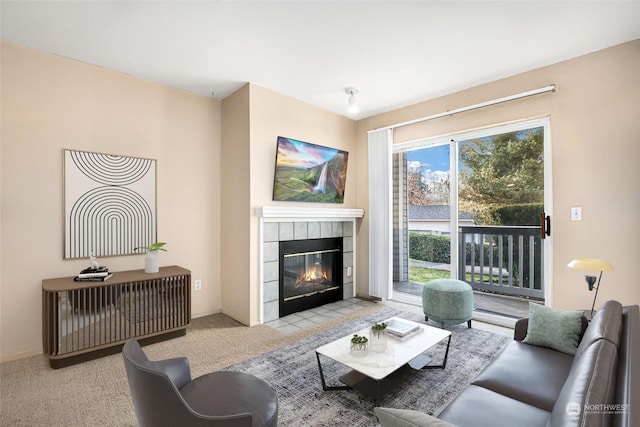 carpeted living room with a tiled fireplace