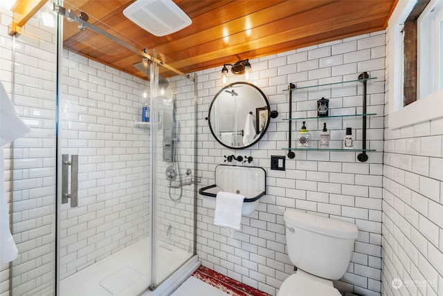 bathroom with toilet, a shower with door, wooden ceiling, and tile walls