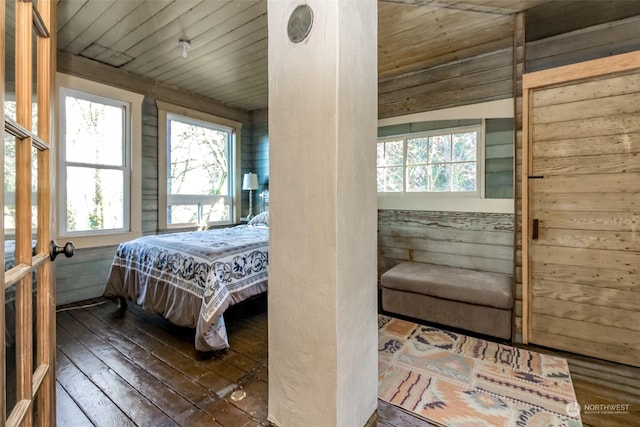 bedroom with wood ceiling, dark hardwood / wood-style flooring, and wood walls