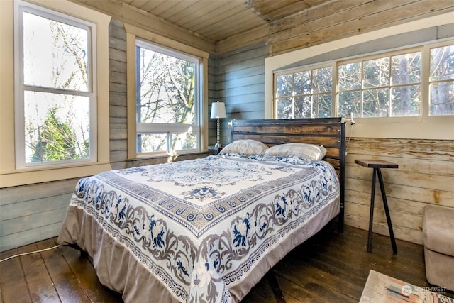 bedroom featuring wooden walls and dark hardwood / wood-style flooring