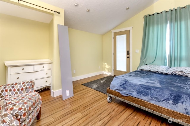 bedroom featuring light wood-type flooring and vaulted ceiling