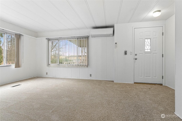 entrance foyer featuring plenty of natural light, a wall mounted AC, and carpet floors