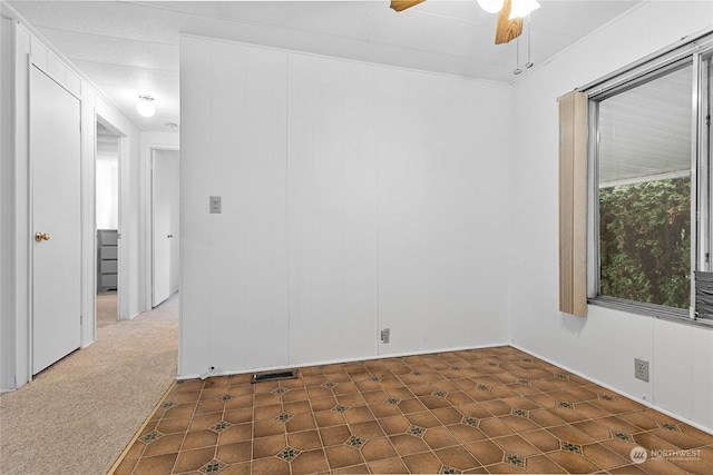 carpeted spare room featuring ceiling fan