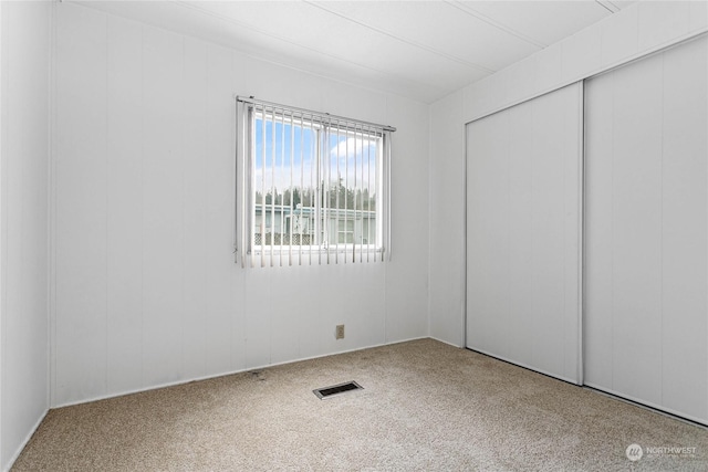 unfurnished bedroom featuring carpet floors and a closet