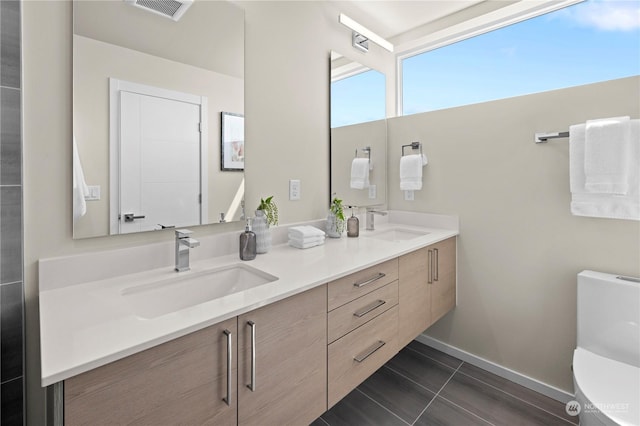 bathroom with tile patterned flooring, vanity, and toilet