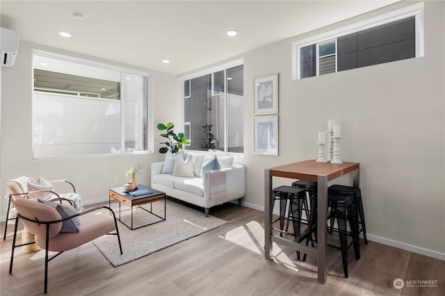 living room featuring light hardwood / wood-style flooring and a wall mounted AC