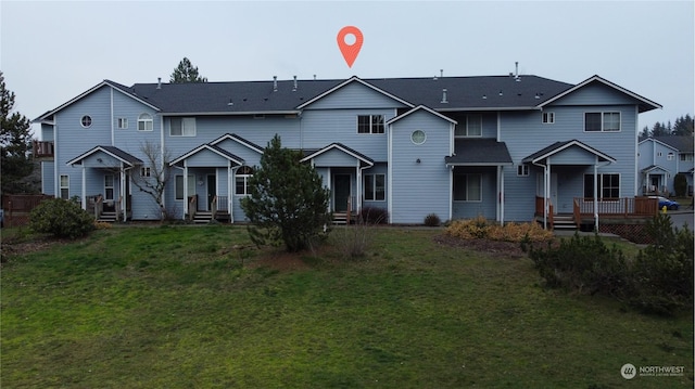 rear view of property featuring a lawn