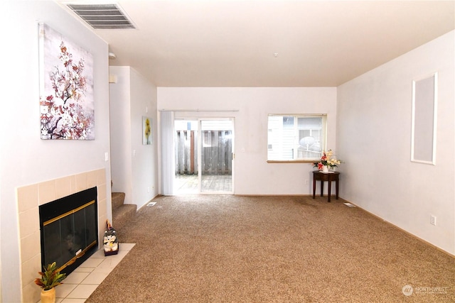 living room with a tiled fireplace and light carpet