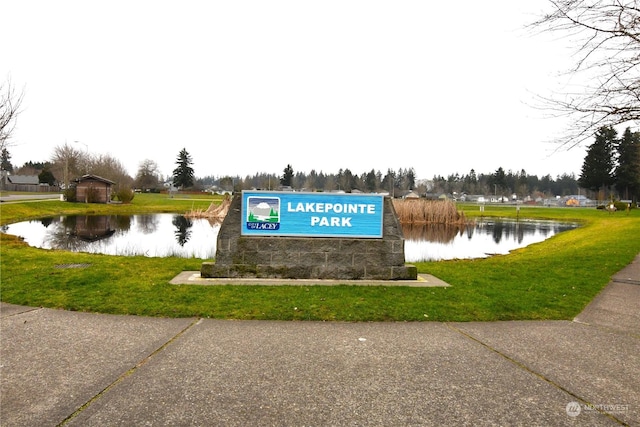 view of property's community featuring a lawn and a water view